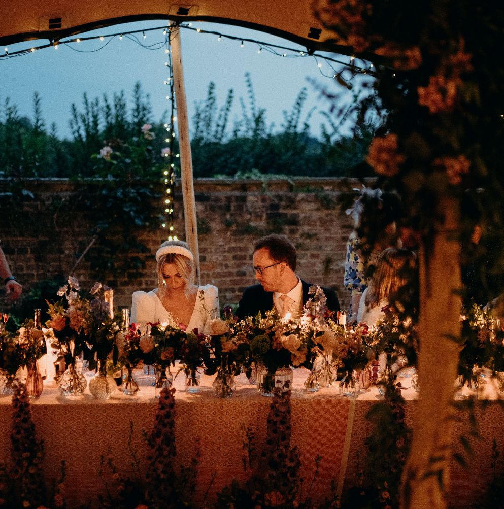 married couple sat at table at wedding