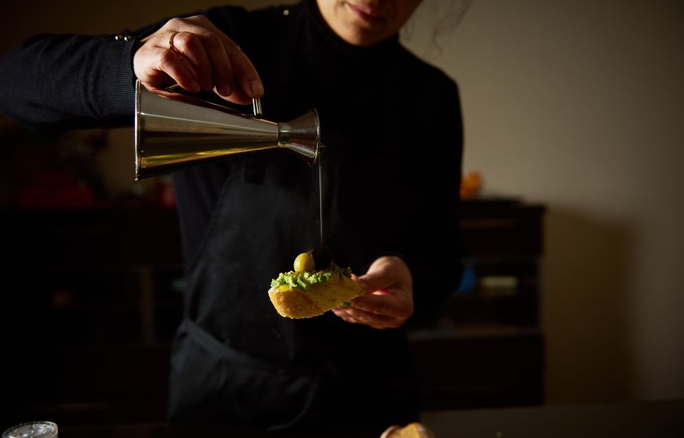 man pours oil onto an appetiser