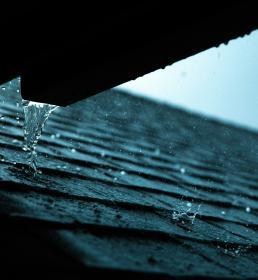 Excess water falls from gutters onto a roof