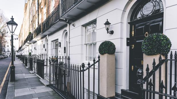 The front of a Georgian terraced house, with white front and black front doors
