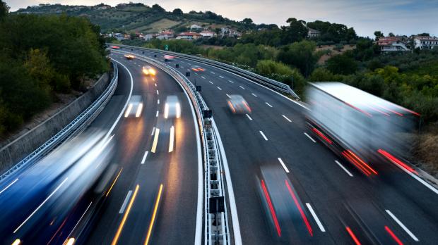 A movement shot of cars driving on a motorway at twilight