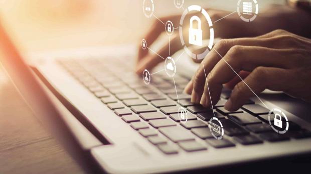 Fingers on a laptop with security icons