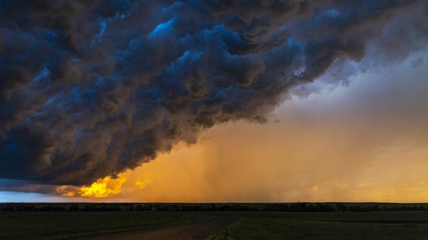 Ominous black storm clouds obscuring the sun