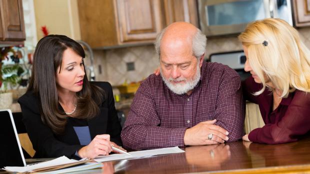 Mature couple at table with female solicitor