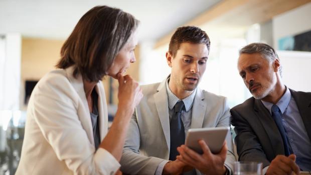 Colleagues deliberating over an ipad