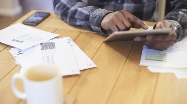 Man with bills and ipad