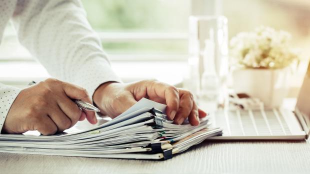 Hands flicking through pile of files