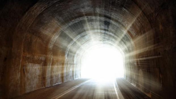 Dark tunnel with light streaming in