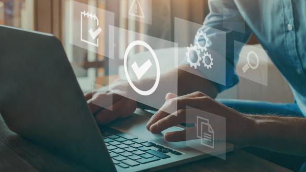 Man sat at his laptop checking off tasks