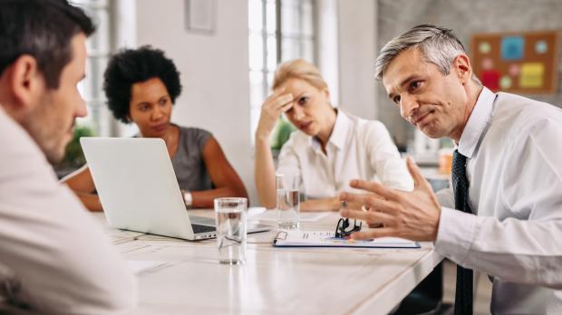Businessmen and women disagreeing during a difficult meeting