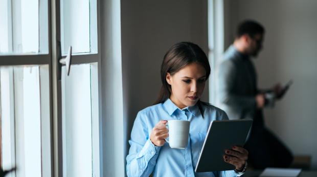 Woman reading notes with a cup of coffee