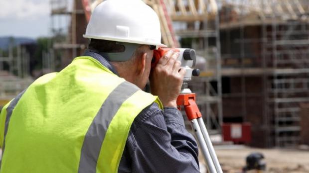 Surveyor using a theodolite