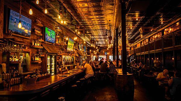 Inside of a bar with people eating and drinking