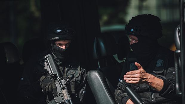 Armed police with guns and wearing balaclavas