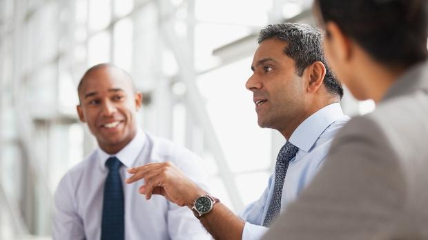 three business people discuss in an office setting