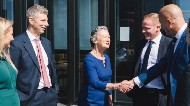 suited business people shaking hands outside office