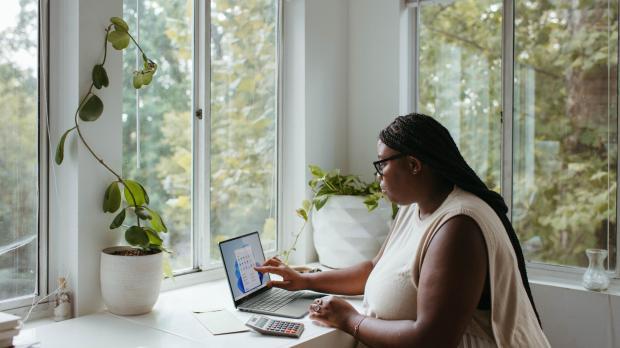 woman sat at a desk working on a laptop