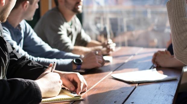 group of business people at a table discussing 