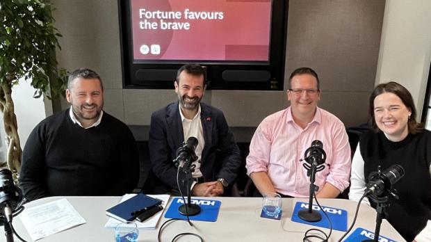 A nice group shot, of four professionals with podcast equipment 