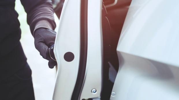 close hand pulling handle car thief