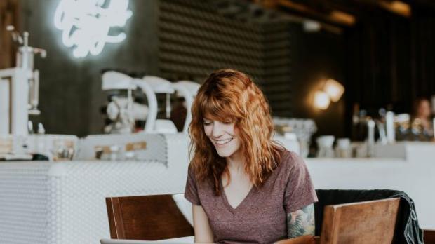 Woman sat at a laptop in a cafe bar