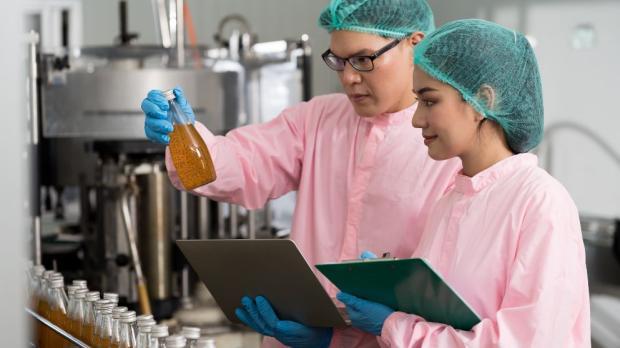 two scientists observing phial of liquid