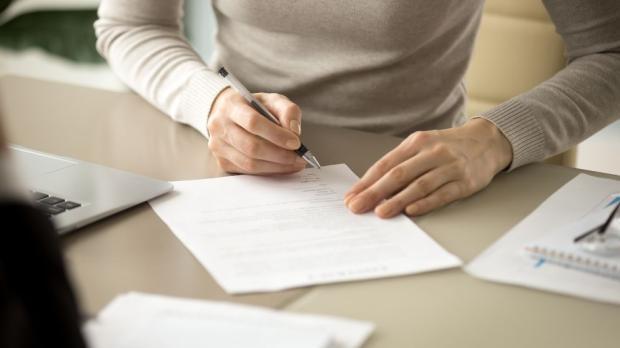 woman signing a document