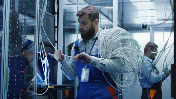 technician changing wires in server room