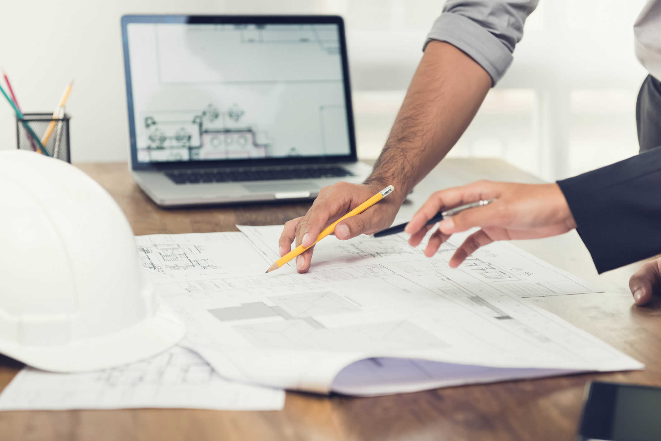 Two planning consultants discuss blueprints