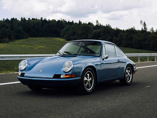 classic car driving in countryside