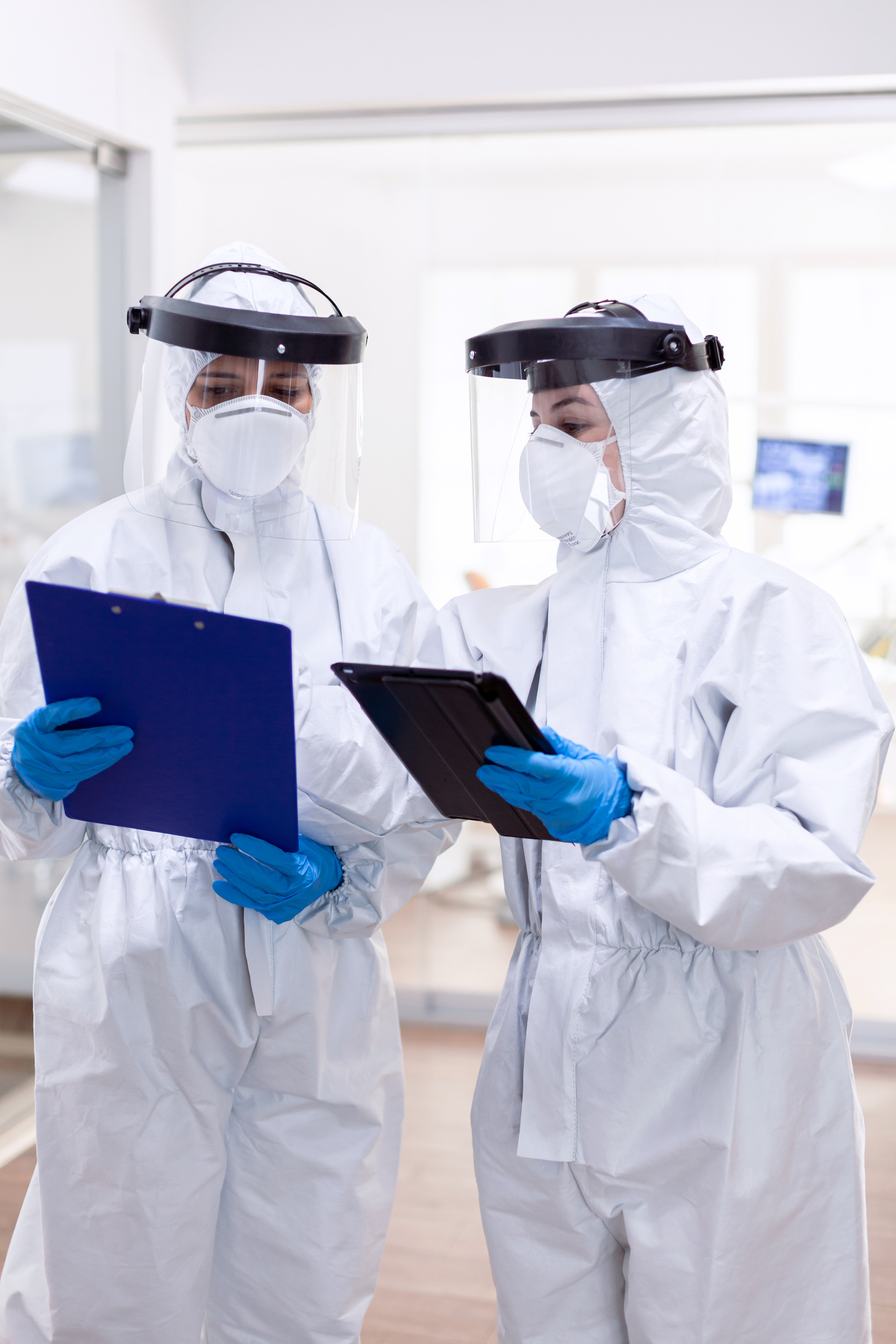 two workers in PPE gear in a medical setting