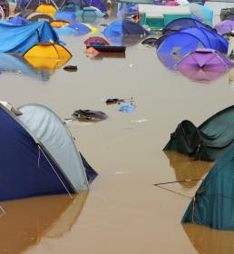 Tents sit in deep muddy flood water
