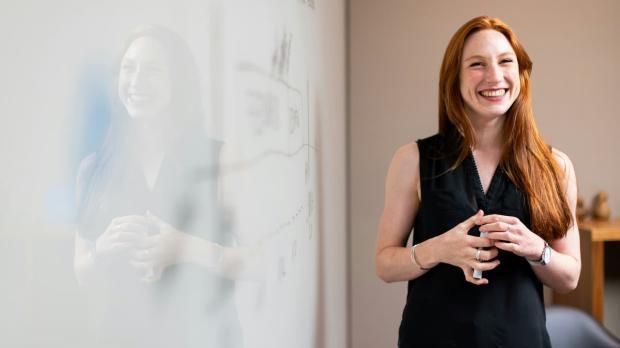 Woman standing next to whiteboard