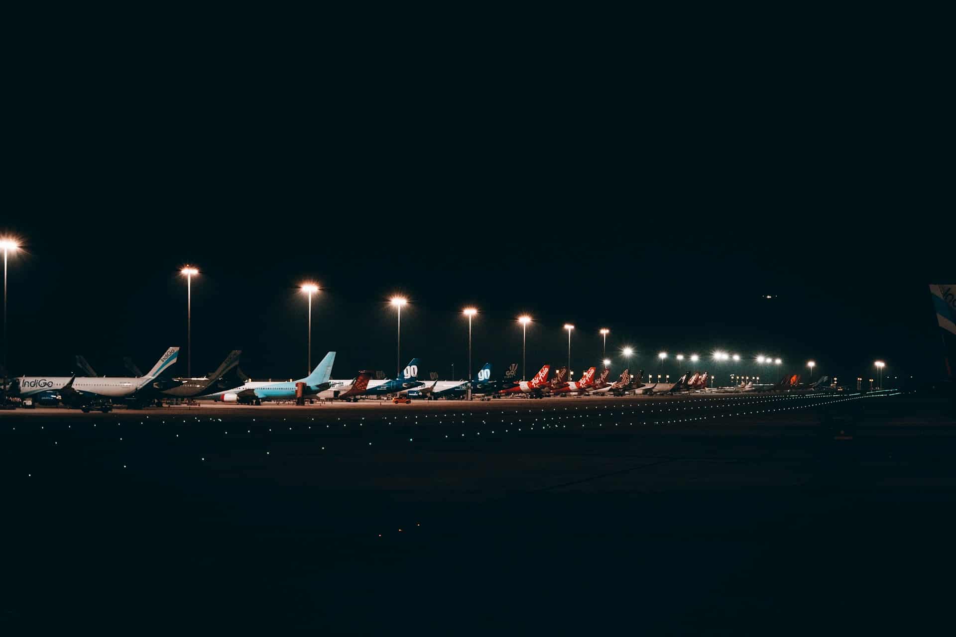 Planes parked up beside the runway at an airport 
