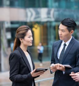 A group of three business managers have a serious discussion outside the office