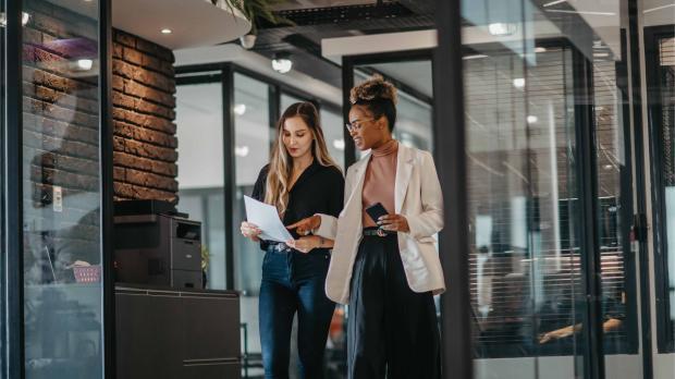 Young female employees walking down the company corridor 