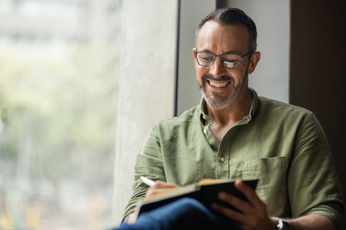 A man smiling reading