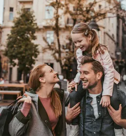 parents with child laughing and smiling, piggy back