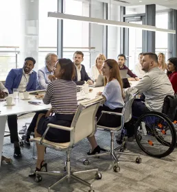 Large group of professional people sat around a board room table