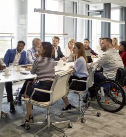 Large group of professional people sat around a board room table