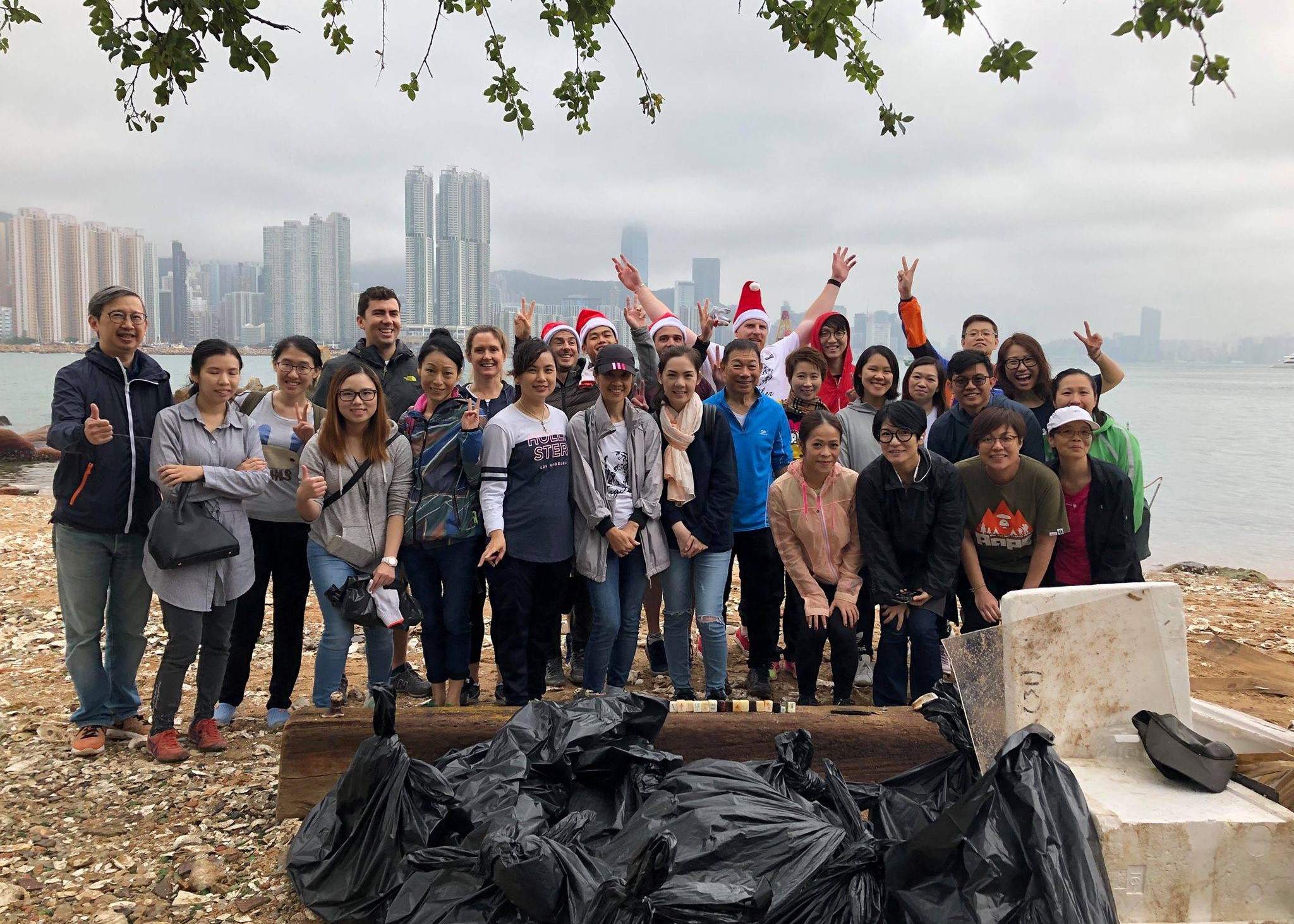 Howden group of staff on a beach volunteering and cheering