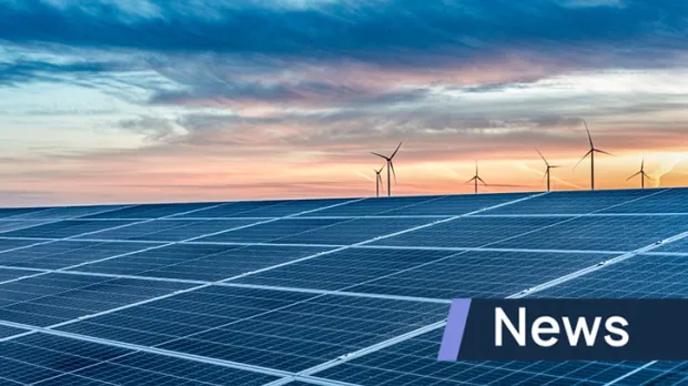Solar panels during sunset with wind turbines in the distance