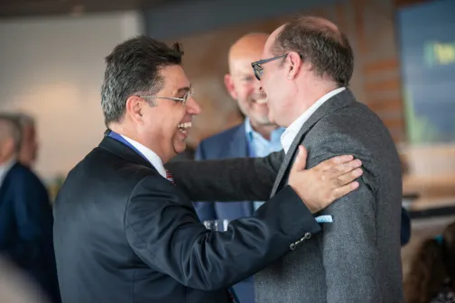 A photo of two Howden leaders greeting each other at a conference
