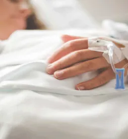 personne sur un lit d'hôpital avec perfusion