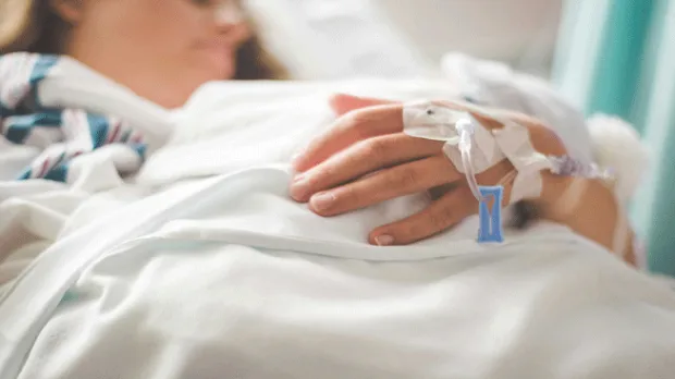 personne sur un lit d'hôpital avec perfusion