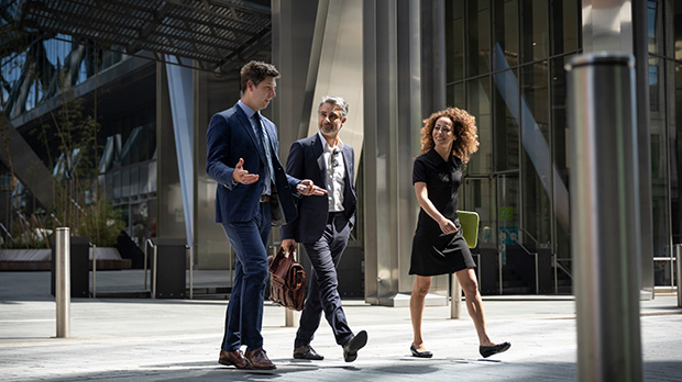 Business people walking and talking in front of an office