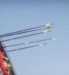 Archery arrows in target board blue sky