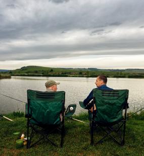 two men angling in lake - angling insurance clubs and syndicates - Howden