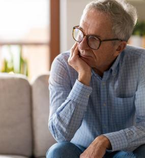 Worried man sitting alone in his home