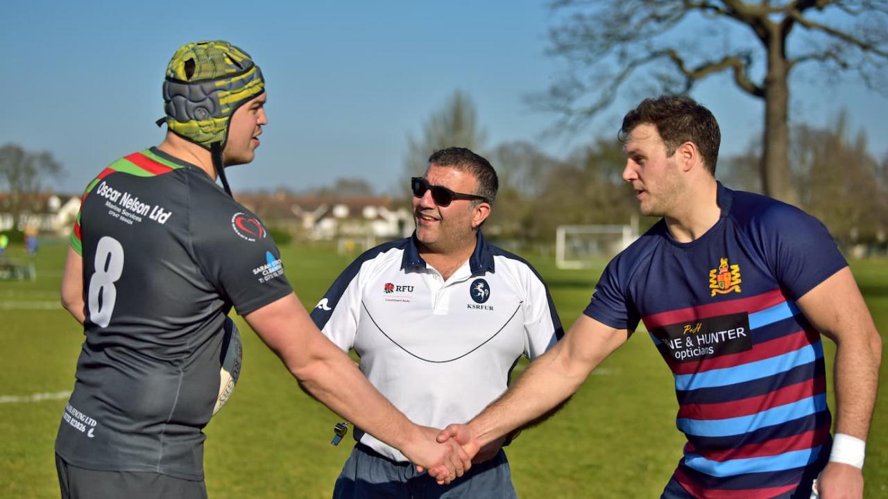 Rugby referee officiating the coin toss 